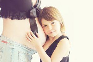 ילדה מאזינה לתינוק בבטן הריונית - כאבי גב בהיריון יש טיפול